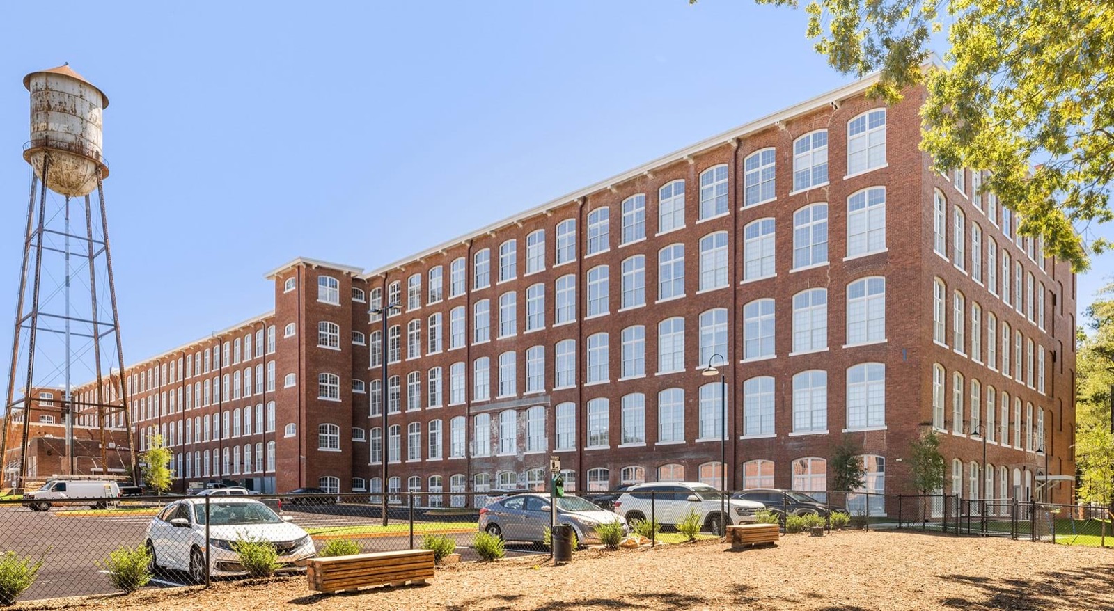 The red brick Woodside Mill building with arched windows and the water tower beside it